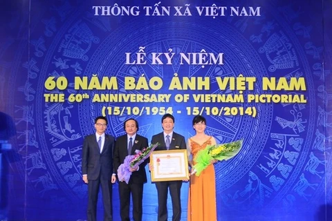 Deputy Prime Minister Vu Duc Dam (first, left) grants third class Independence Order to Vietnam Pictorial (Photo: VNA) 